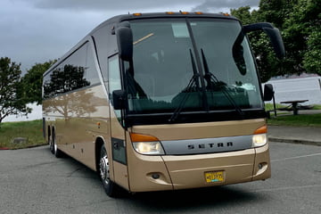 a copper-colored setra charter bus parked in a lot