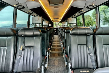 clean leather seats in two rows in the interior of a charter bus